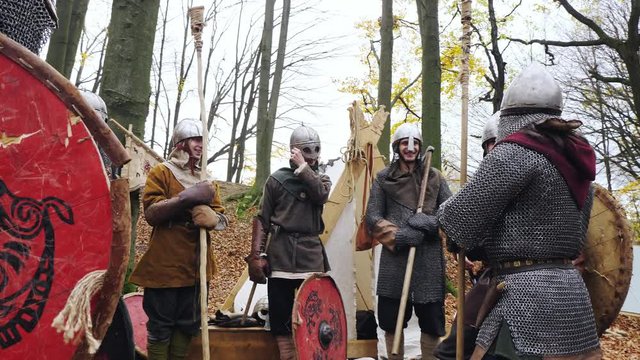 A group of Vikings in the woods discusses a hike