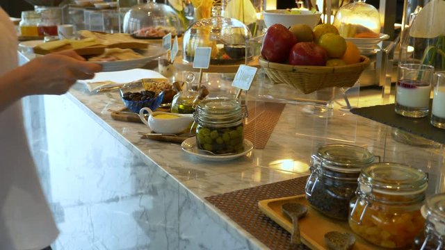 Self service took the food from the buffet line. the woman is preparing a sandwich for breakfast. 4k.