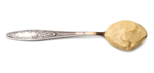 mustard in spoon isolated on white background top view