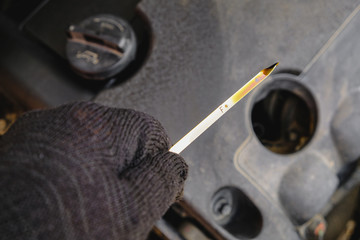 checking the oil level in a car engine