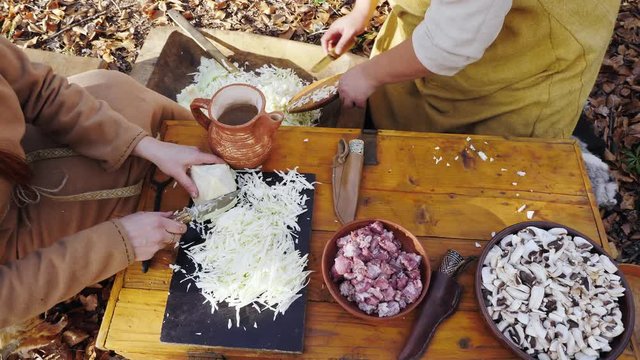 Womens viking are cooking in the forest camp. Womens talking and smiling