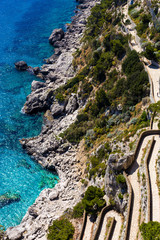 A view from above on a winding road in the rock and turquoise water of the sea. Via Krupp at Marina...