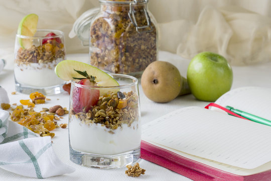 Healthy breakfast or snack with homemade yogurt with strawberries and granola in a glass. The concept of a healthy lifestyle, healthy food, diet. Food diary notes.
