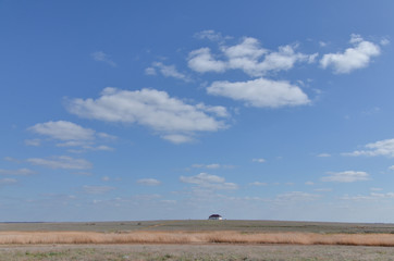 desolate white house surrounded by vast fields of steppe in Volga estuary Astrakhan region, Russia