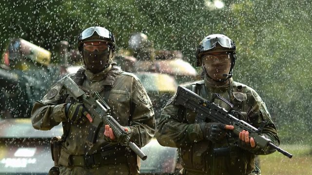 Military men in the rain, slow motion