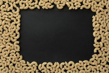 Pasta on black background. Place for text.