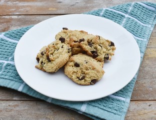 Almond flour chocolate chip cookies on a white plate and dish towel
