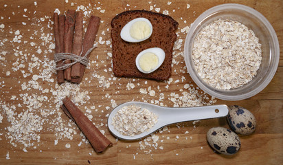 quail eggs on a black bread and oat chips in a cup and cookie and a cinnamon stick