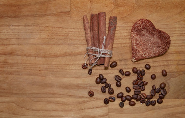 cookie and cinnamon stick and coffee beans on a broun wooden table