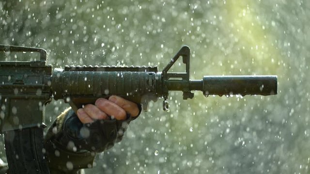 Holding gun in the rain, slow motion