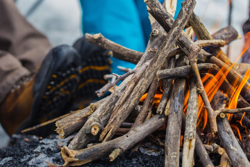 A bonfire is burning In winter in outdoors. Heating feet from fire