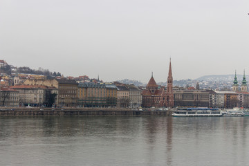 Fototapeta premium Landmark Budapest and Danube river in cloudy day. Old european city with reflection in water and motor ship on river. Panorama of Budapest, Hungary. Travel and tourism concept. Cityscape. 