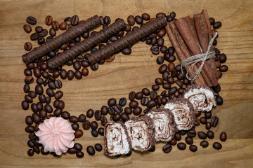 chocolat sticks and meringue and cinnamon stick and coffee beans and turkish delight on a broun wooden table