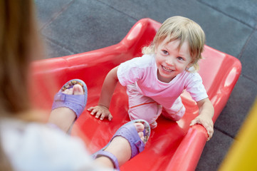 Fototapeta na wymiar Boy on playground slide. Little blond boy playing on slide in tropical resort