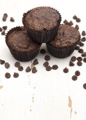 Whole Wheat Double Chocolate Chip Muffins on a Rustic White Wood Table