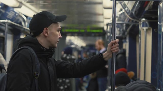 Man Student With Backpack Holding Handrail During Riding In Subway Train