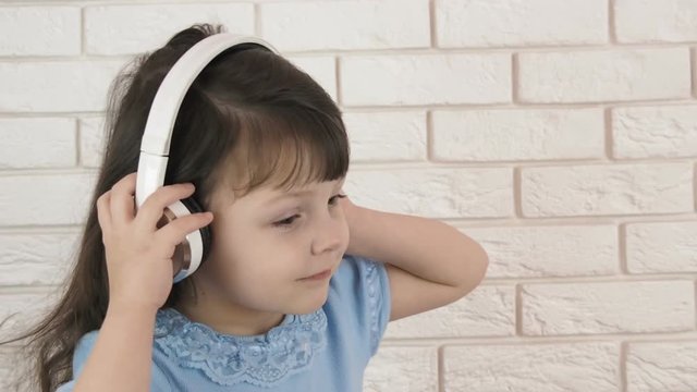 Child in headphones. Little girl is dancing in headphones.