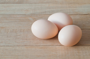 Three eggs on a wooden table