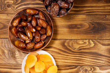 Dried apricots and dates fruit on wooden table. Top view