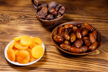 Dried apricots and dates fruit on wooden table