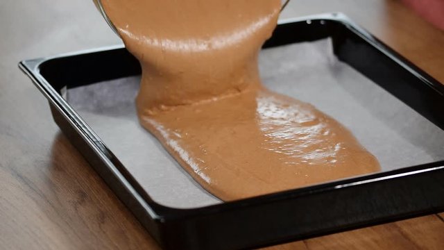Pouring cake mix into baking tin. Making Chocolate Layer Cake.