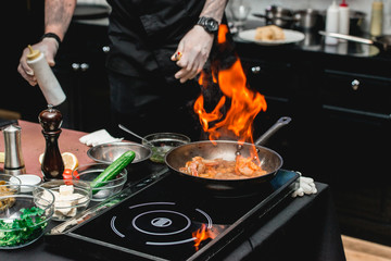 The chef cooks the shrimp on a metal frying pan