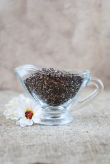 Fototapeta na wymiar Chia seeds in a glass jug on a linen tablecloth