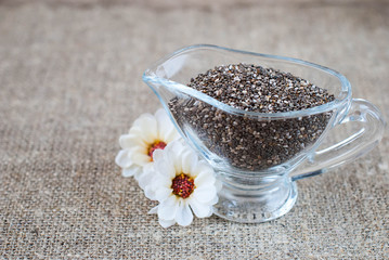 Chia seeds in a glass jug on a linen tablecloth