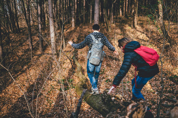 Father and daughter crossing over old tree log