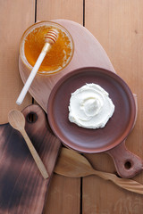 Sour cream, cream, fresh sour cream in pottery on a wooden background, dairy products and honey, wooden board, French breakfast, healthy food, sour cream and honey in a rustic style, minimalism, copy 