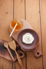 Sour cream, cream, fresh sour cream in pottery on a wooden background, dairy products and honey, wooden board, French breakfast, healthy food, sour cream and honey in a rustic style, minimalism, copy 