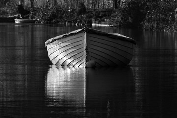 A small wooden row boat converted to black and white