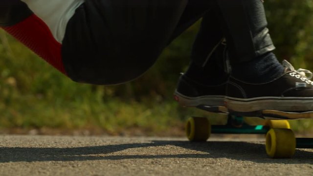 Close of of longboarder on the road, slow motion