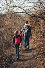Father and daughter hiking on forest trail