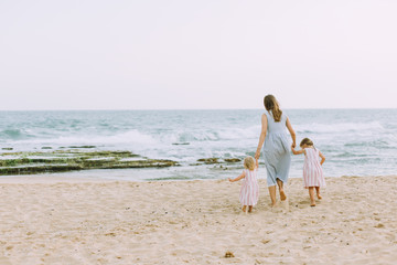 Young mother with two daughters on the beach