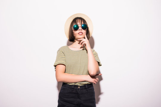 Pretty hipster teen girl in sunglasses and a straw hat isolated on white background