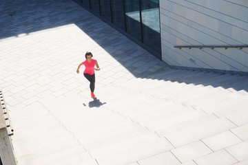 Young, fit and sporty woman running up the stairs. Fitness, sport, urban jogging and healthy lifestyle concept.
