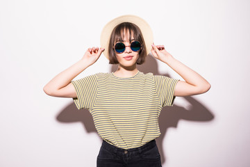 Young fashionable attractive hipster teen girl in sunglasses and straw hat isolated on white background .