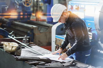 a young successful engineer makes a measurement of the details of the mechanism