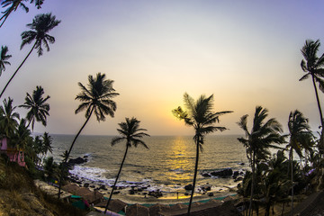 Fototapeta na wymiar Sunset visible through palm leaves