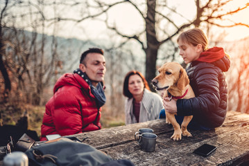 Dog sitting at a picnic table with owners