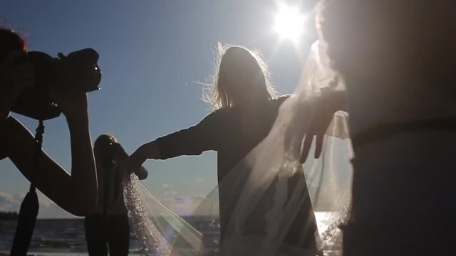 Photographer taking photo of waving bridal veil silhouette