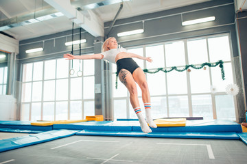 Twine young woman jumping on trampoline club