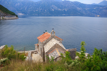 Fototapeta na wymiar old stone Church in Boka Kotor Bay on background of the sea and the green mountains 
