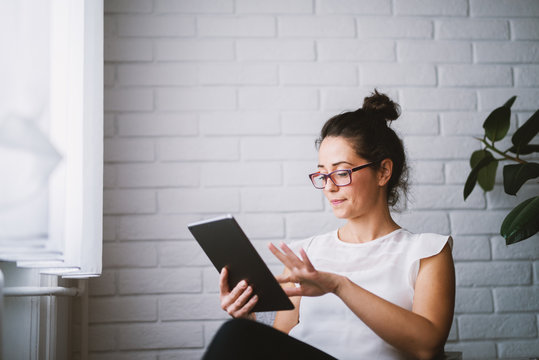 Middle Aged Attractive Woman Looking At Tablet Searching Online.