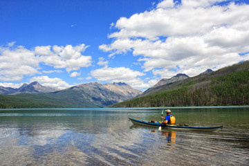 A man kayaking in a glacier-fed lake in North Montana right on the Canadian border.