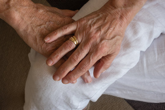 Close up of older woman's hand covering older man's hand (selective focus)