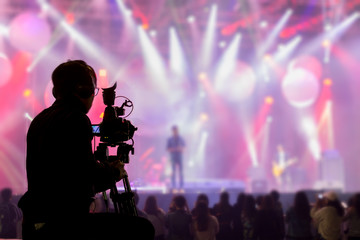 Fototapeta na wymiar The filmmaker is recording and broadcasting live concerts on camcorders. Professional Video Recording Business