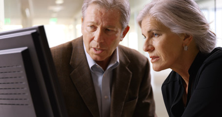 Obraz premium Senior white male customer looking at purchases on monitor with vender