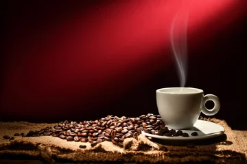Gordijnen Cup of coffee with smoke and coffee beans on reddish brown background © amenic181